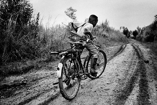 A child soldier rides back to his base in Ituri district, northeastern Congo. 2003. © Marcus Bleasdale/VII Photo Agency