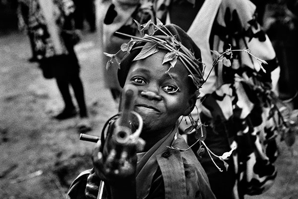 A child soldier with the Mayi-Mayi militia waits in Kanyabyonga as CNDP rebels advance. He was recruited while young men in the area were being abducted by the rebel forces. He didn’t want to be forced to fight, so he volunteered with the Mayi-Mayi. 2008. © Marcus Bleasdale/VII Photo Agency
