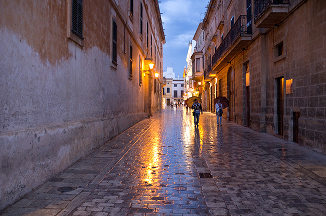 Wet cobbles and umbrellas in the evening.